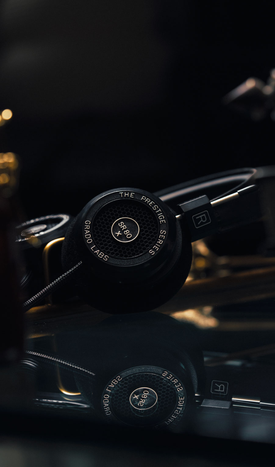 Photo of SR80x on reflective black table with blurred yellow lights in the background